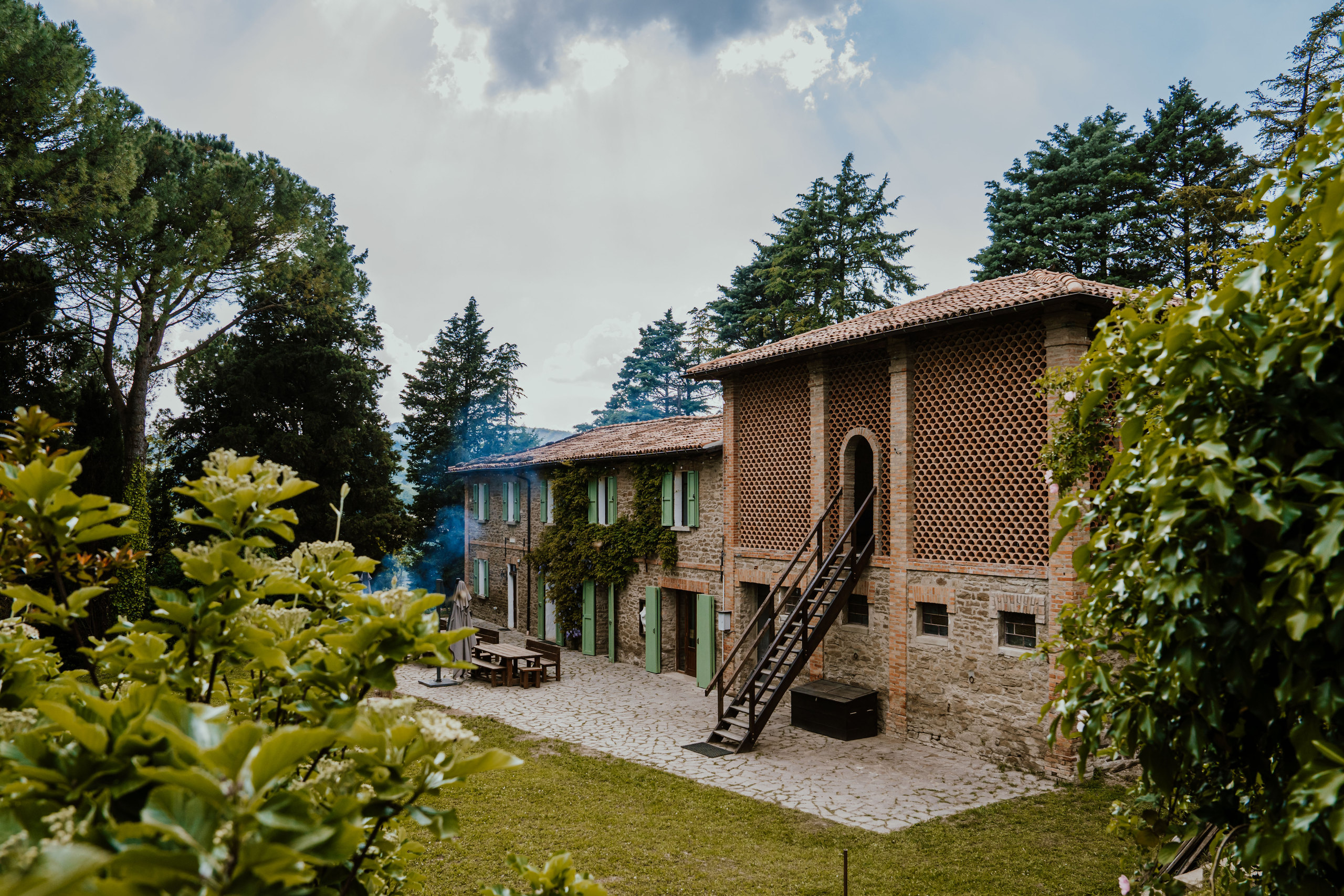 The stone farmhouse and terracotta studio seen from the garden terrace