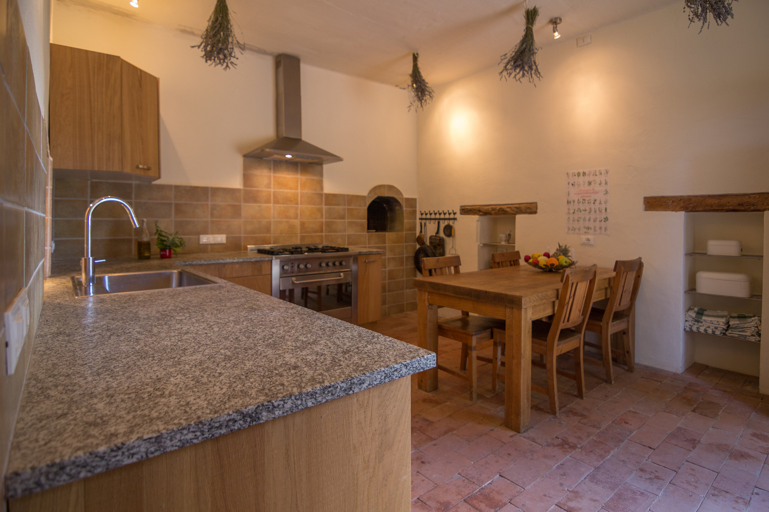 The farmhouse kitchen with wood-fired pizza oven, gas range and communal dining table