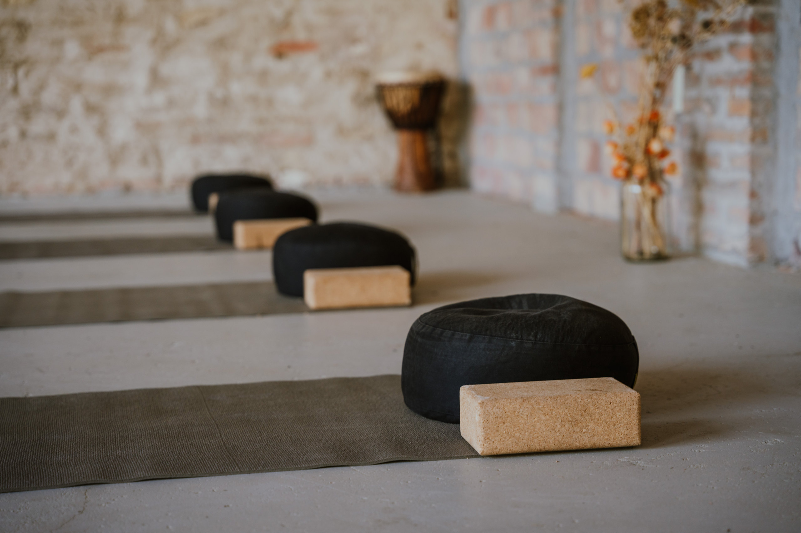 Meditation cushions and cork blocks on yoga mats in the studio